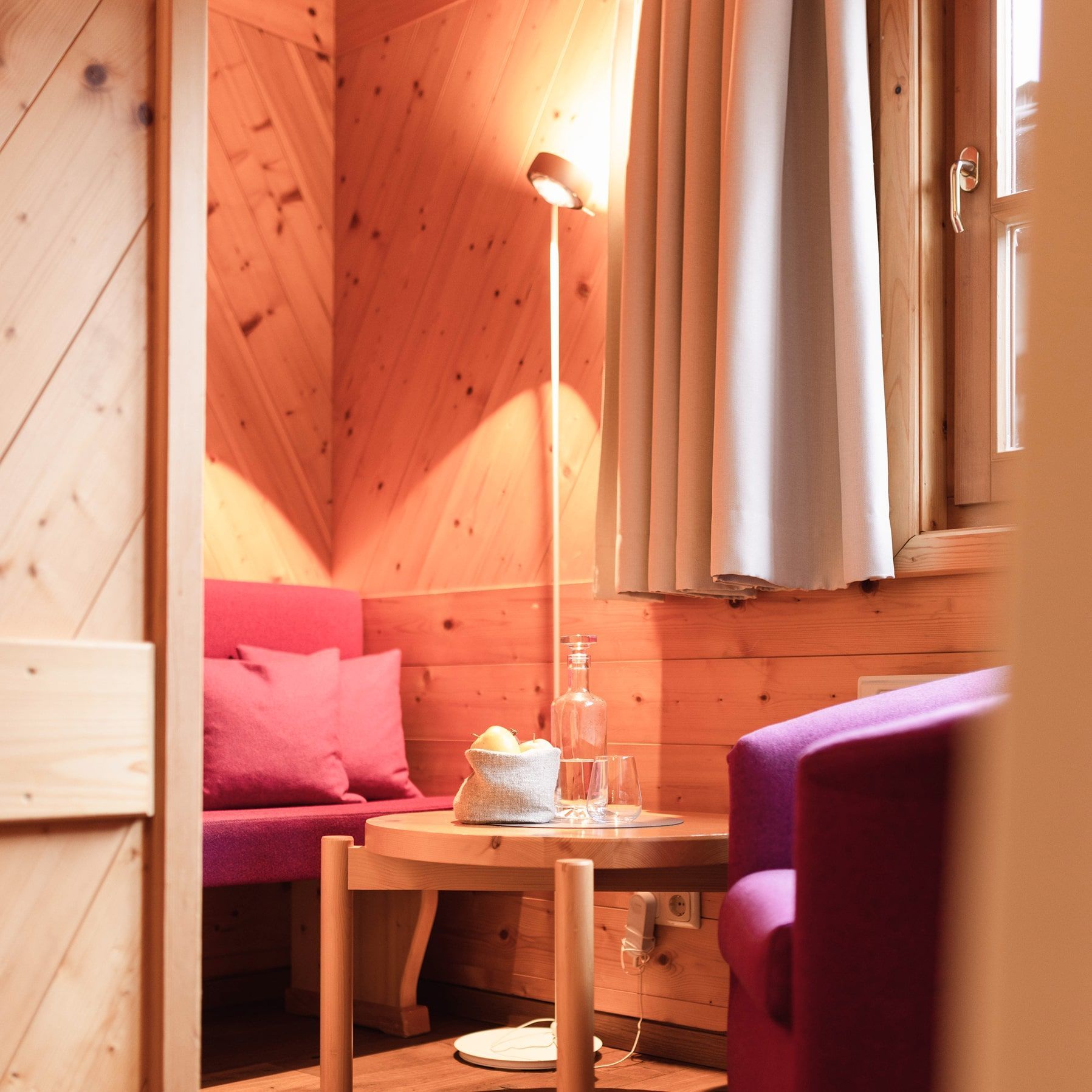 Einladende Ecke im Glemmtalerhof mit Holzdekor, gemütlichen Sitzen und erfrischenden Getränken.