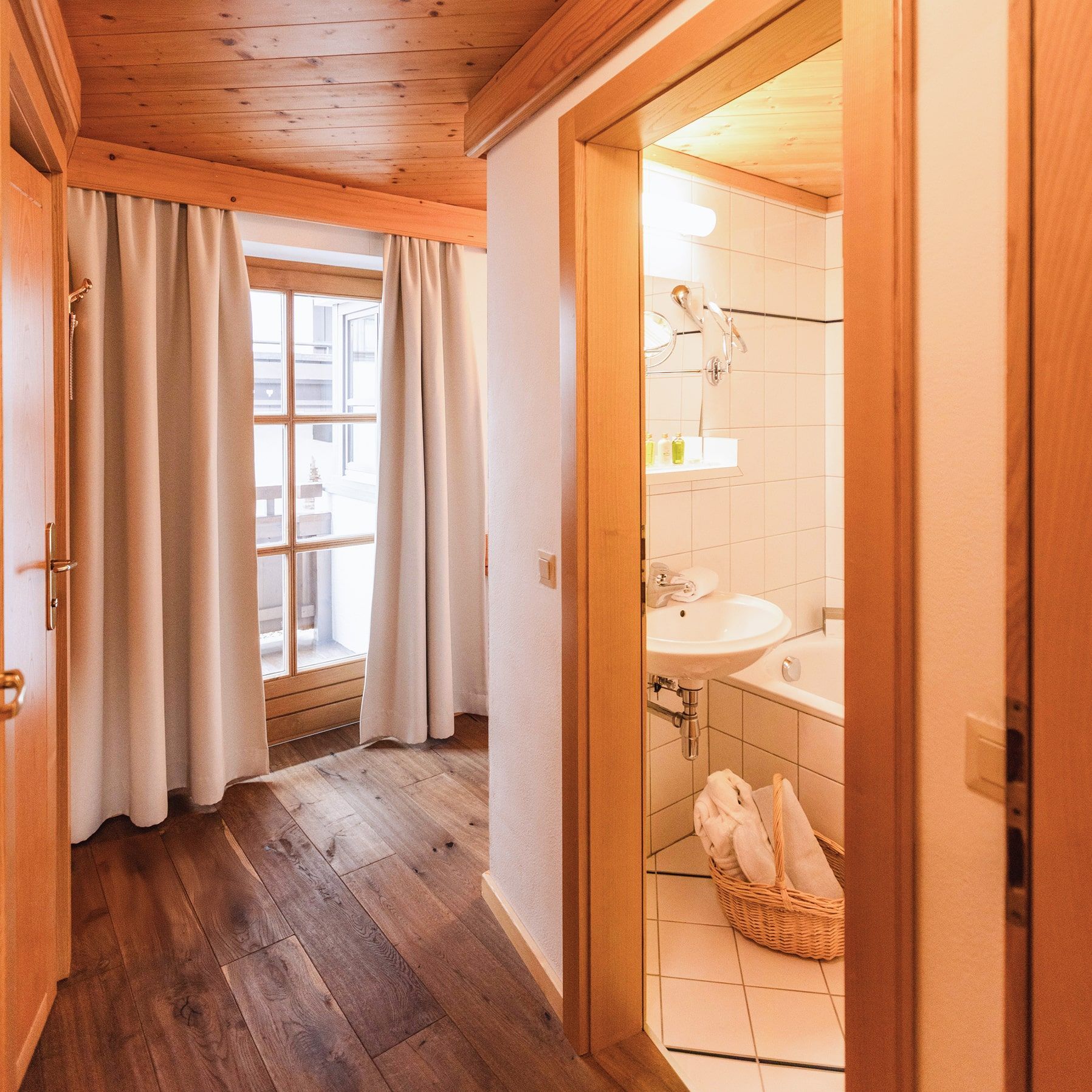 Ein heller Flur mit Zugang zum Badezimmer im Glemmtalerhof in Hinterglemm.
