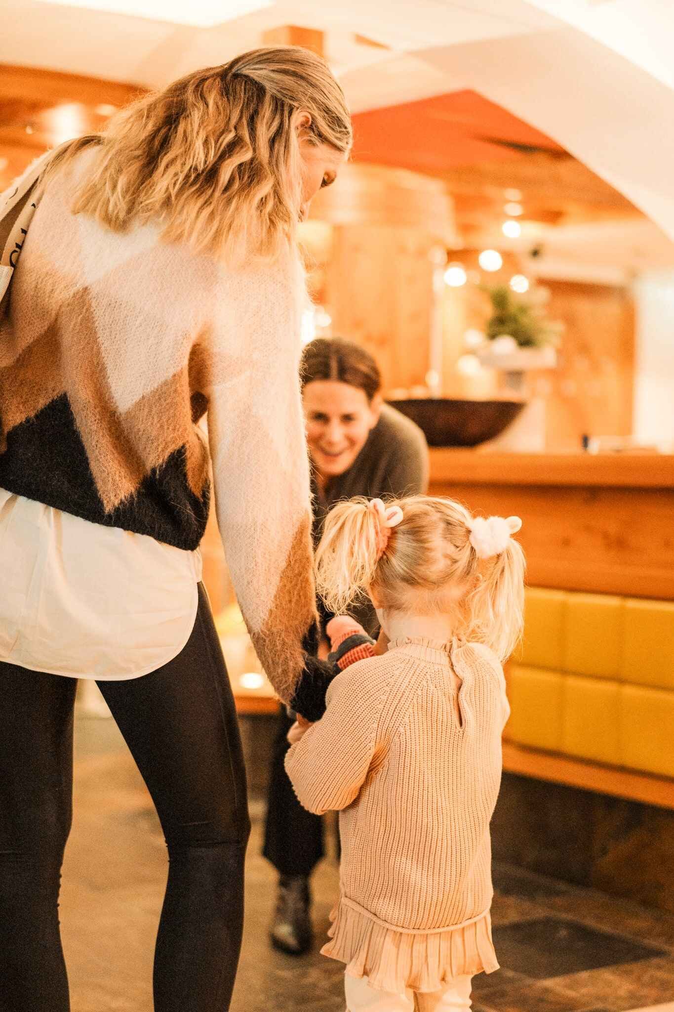 A woman hugs a little girl in the inviting atmosphere of the Glemmtalerhof in Hinterglemm.