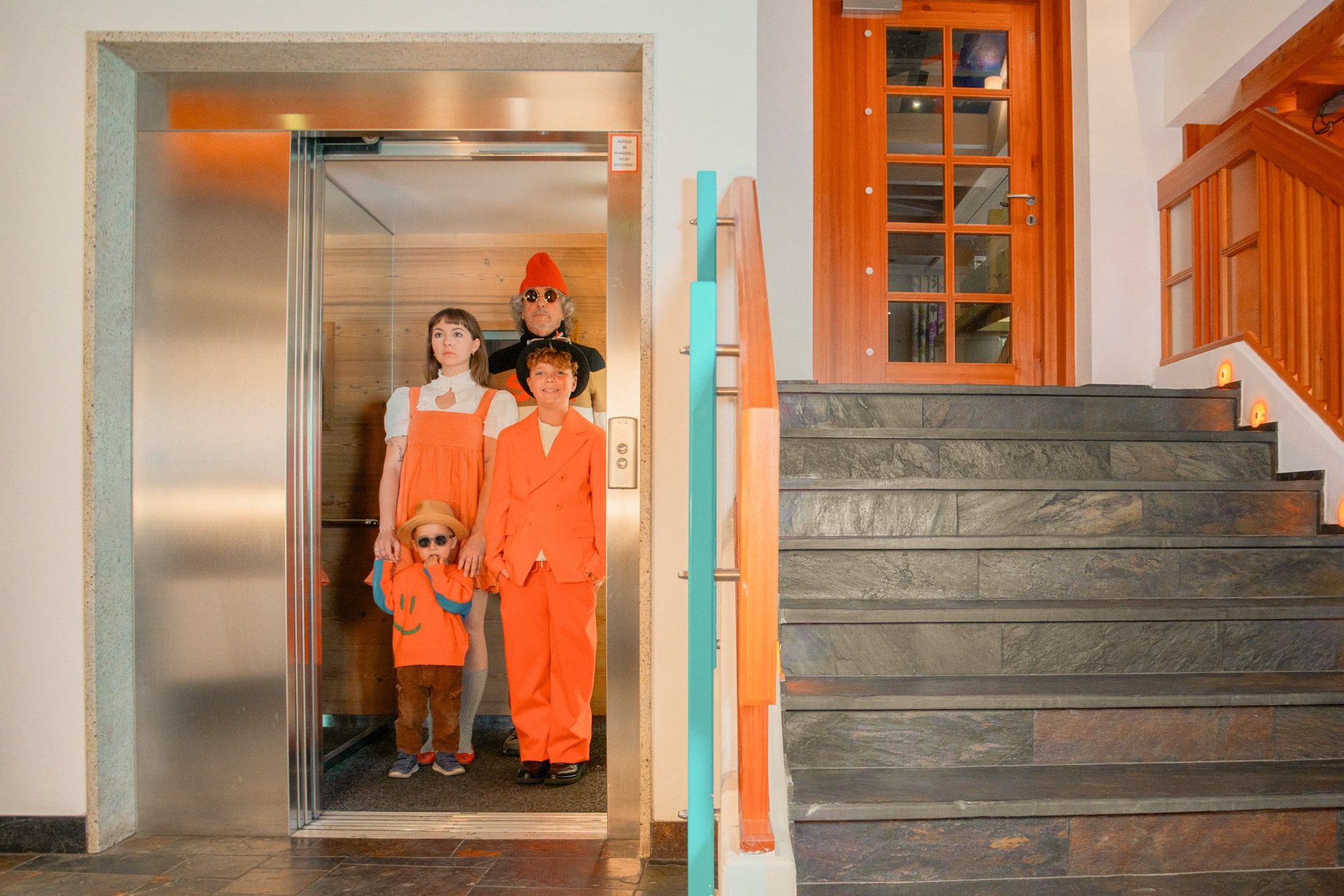 Family in colorful outfits by the elevator at Glemmtalerhof in Hinterglemm.