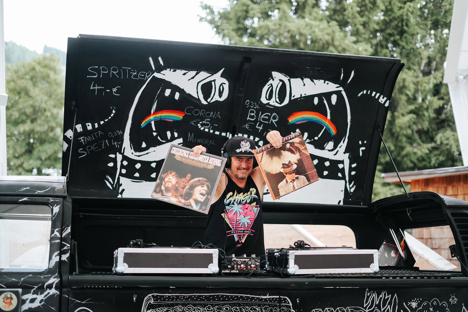 Ein DJ präsentiert Schallplatten vor einem bunten Hintergrund im Glemmtal, möglicherweise in Hinterglemm.