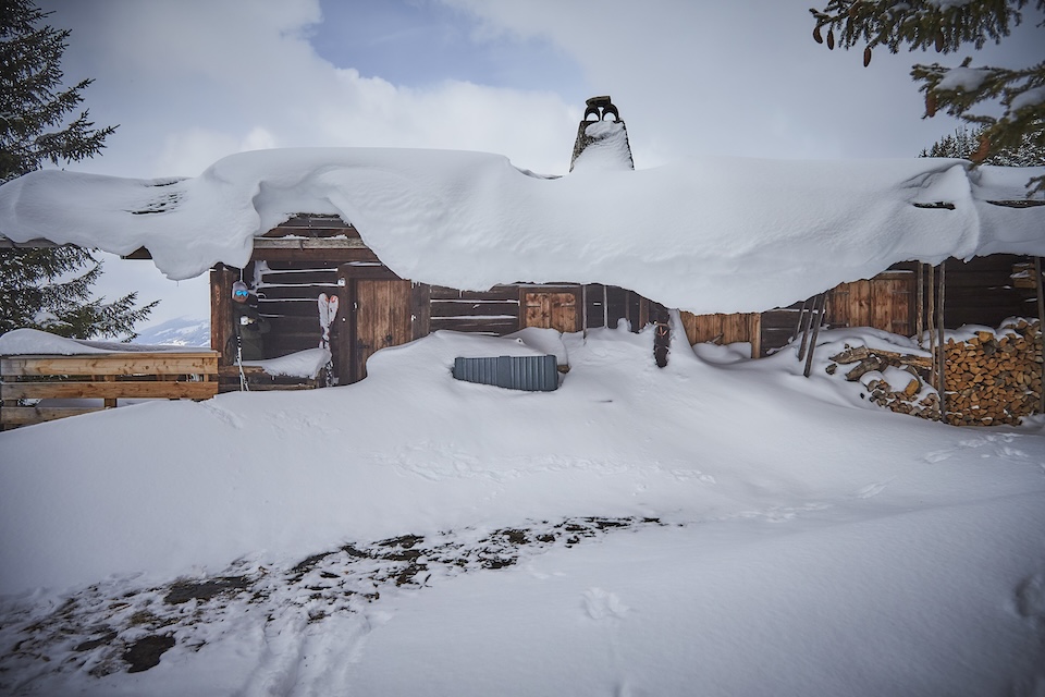 A snow-covered cabin surrounded by a winter landscape in the Glemmtal region, showcasing serene mountain beauty.