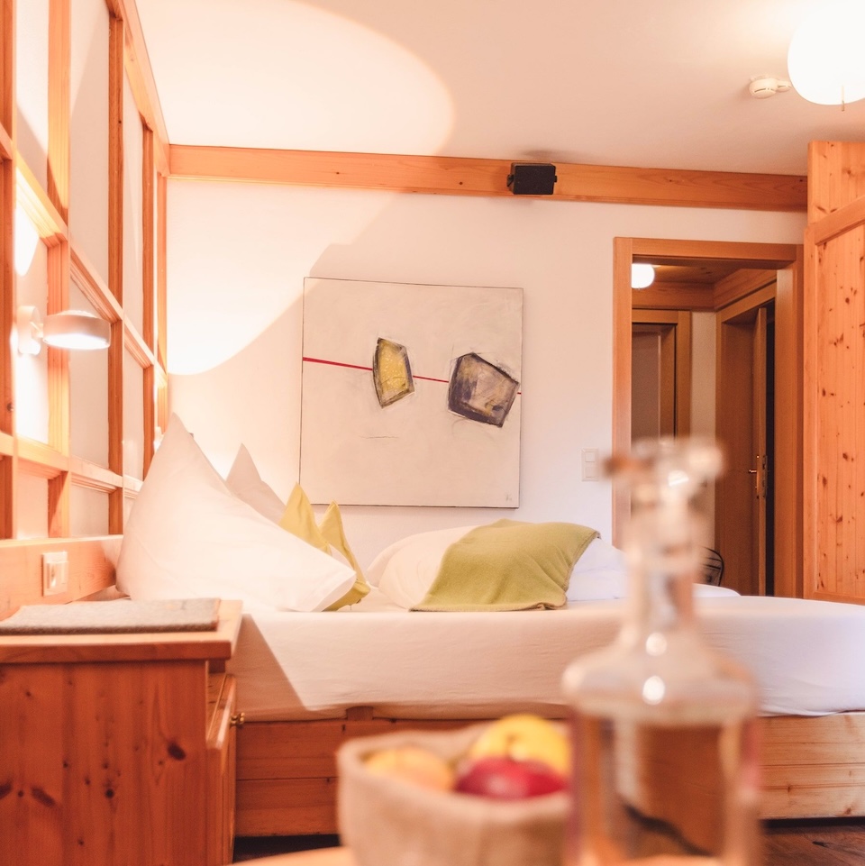 Gemütliches Zimmer im Glemmtalerhof in Hinterglemm mit Kunstwerk, stilvollen Möbeln und frischen Früchten.