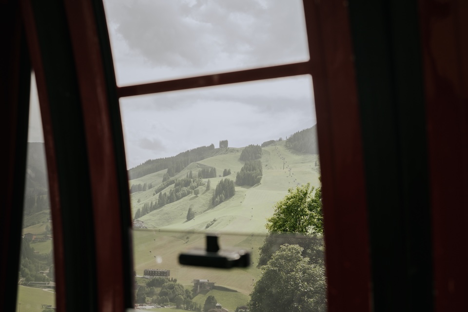 Blick aus der Gondel auf die grüne Landschaft des Glemmtals mit Hinterglemm im Hintergrund.