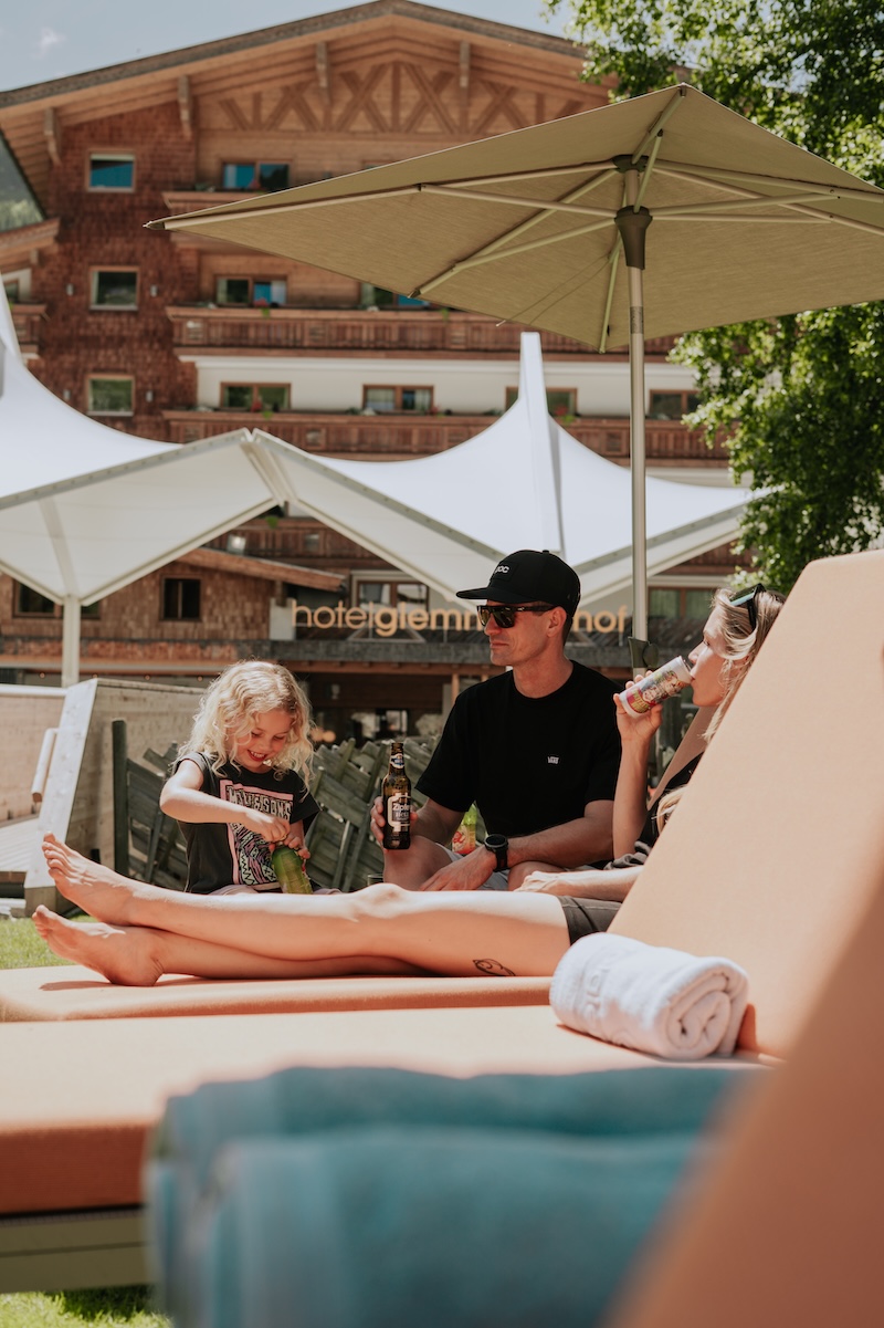 Entspannte Zeit im Glemmtalerhof in Hinterglemm mit Familie bei Getränken auf Liegen in der Sonne.