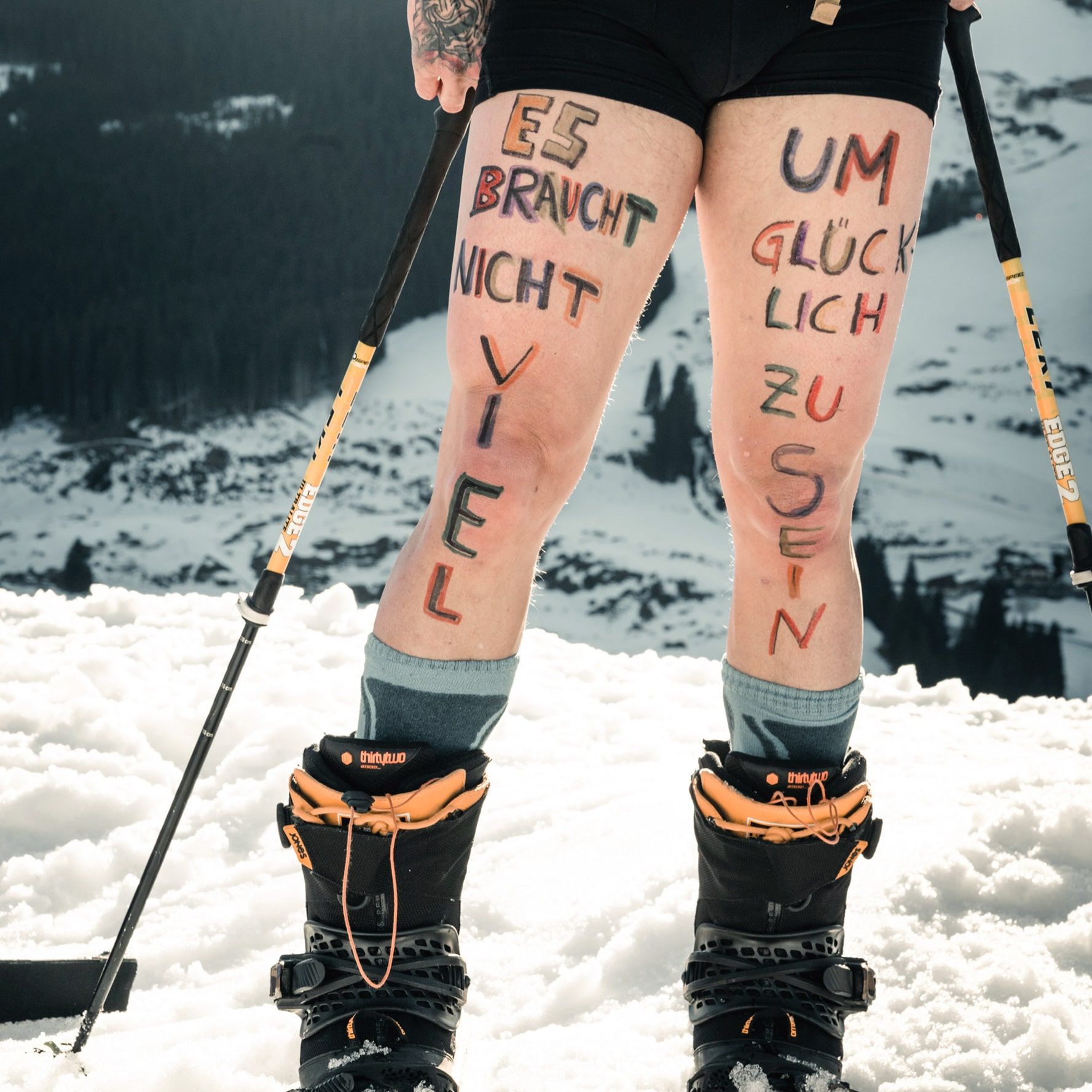 It shows a skier in Glemmtal with a positive quote on their legs.