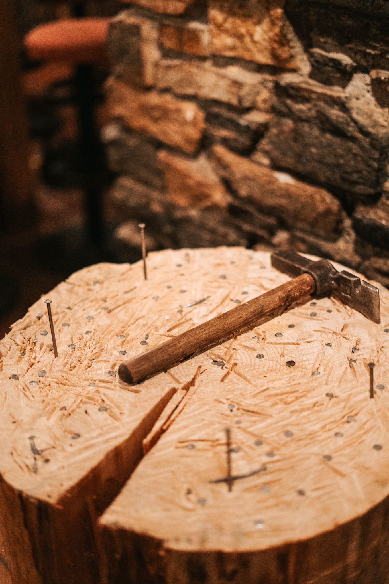 A wooden log with a hammer and several nails in the Glemmtal.