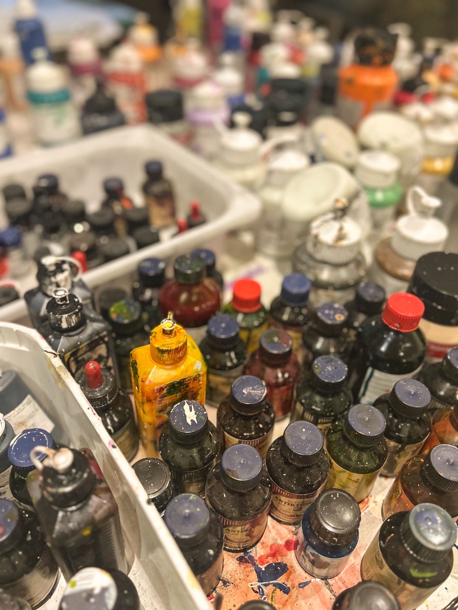 Verschiedene Farben in Flaschen, die Kreativität im Glemmtal anregen.