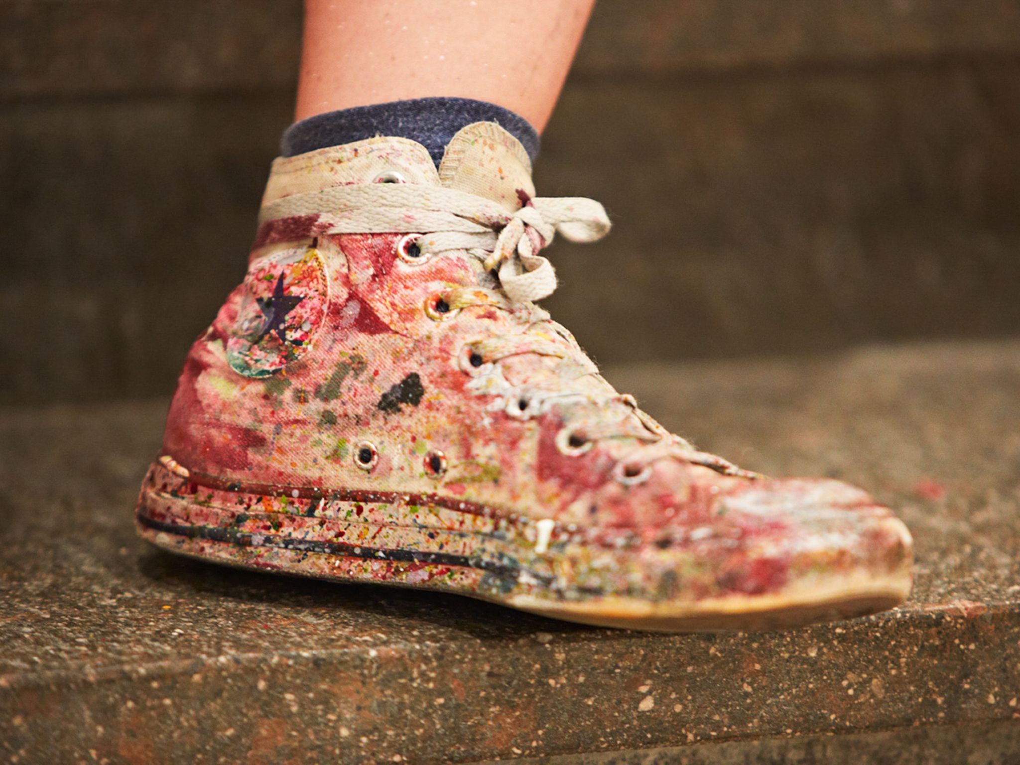Bunt verschmutzter Schuh auf einer Treppe in Hinterglemm. Kreativität im Glemmtal.