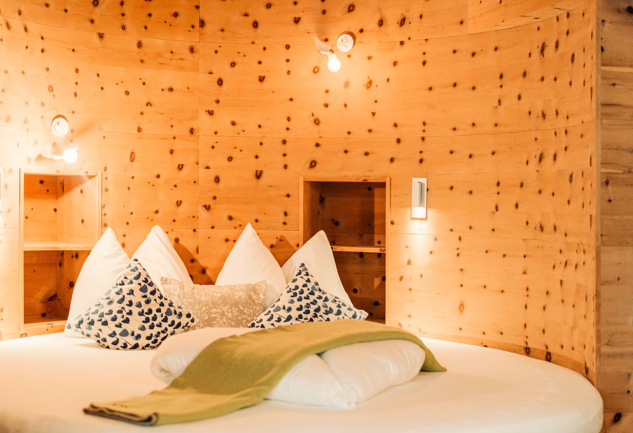 A cozy room at Glemmtalerhof in Hinterglemm with wooden details and stylish pillows.