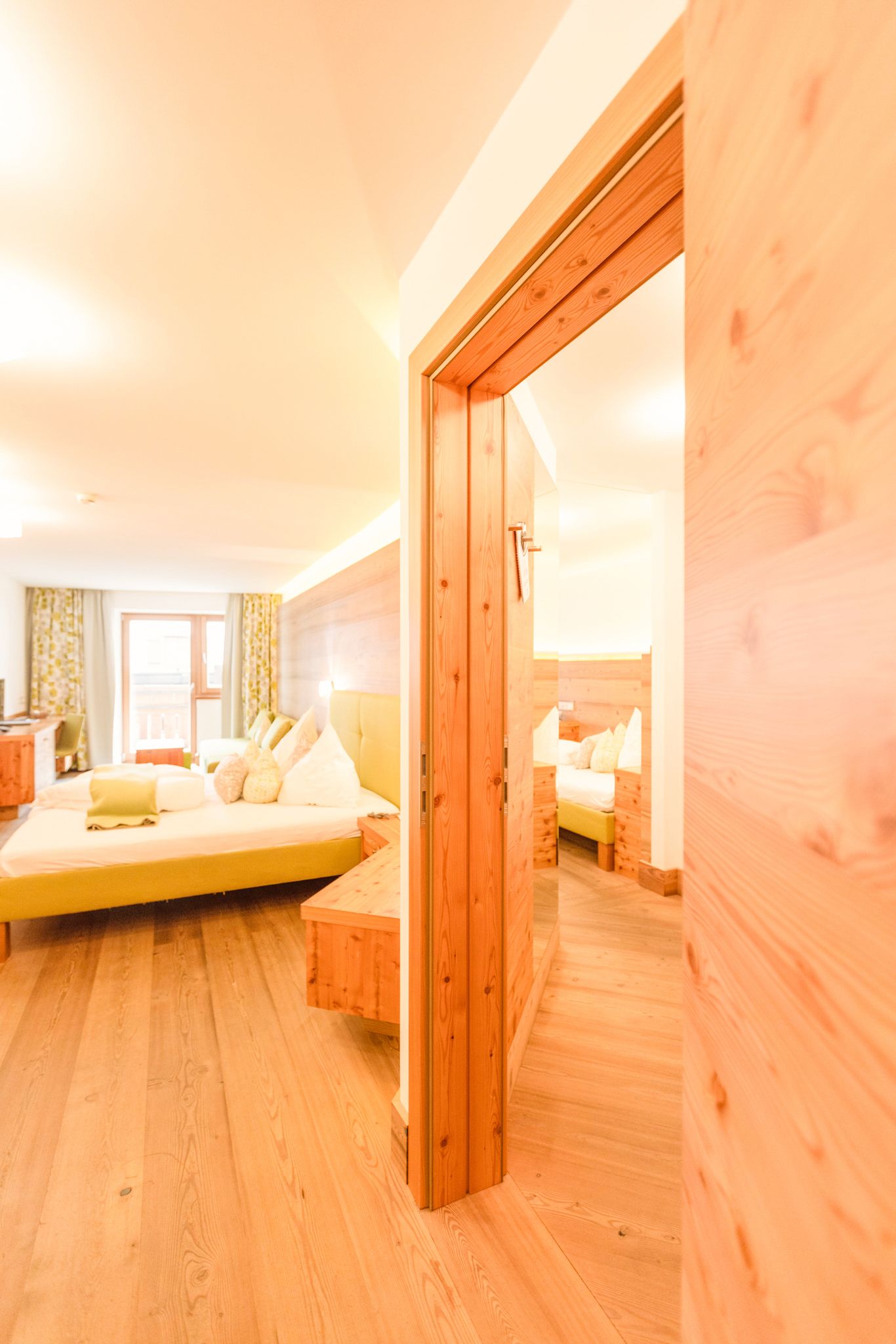 Cozy room at Glemmtalerhof in Hinterglemm with natural wood design and bright colors.