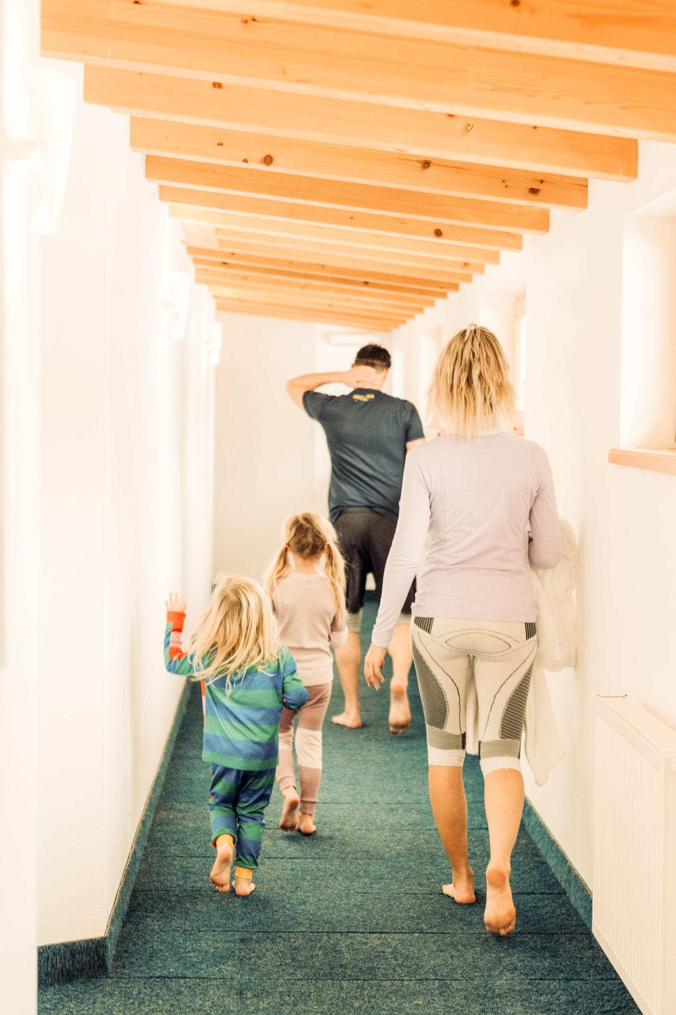 A family walks down a bright corridor in Glemmtalerhof in Hinterglemm.