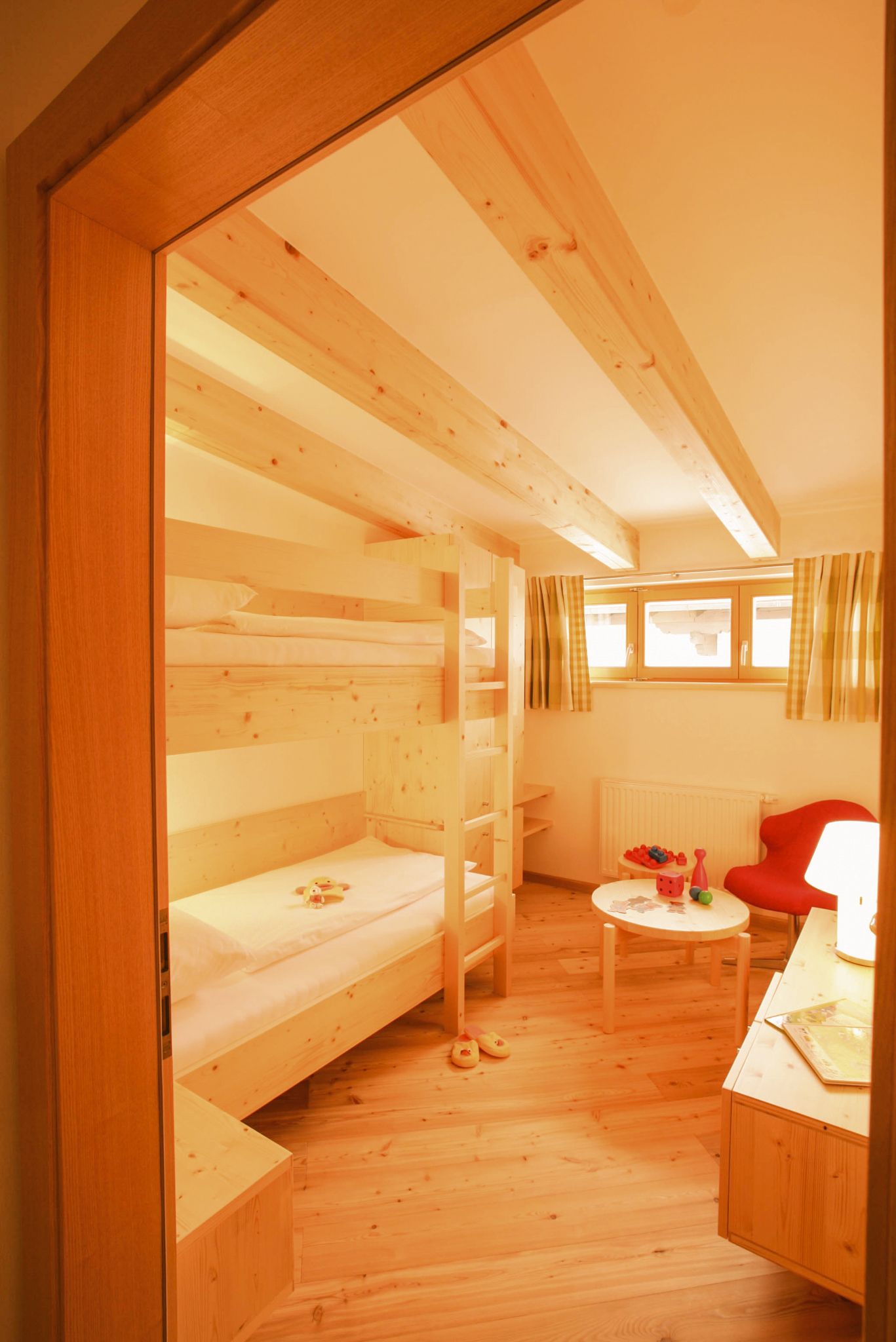 Bright children's room in Glemmtalerhof with bunk bed and toys. Cozy wooden style for family vacation.