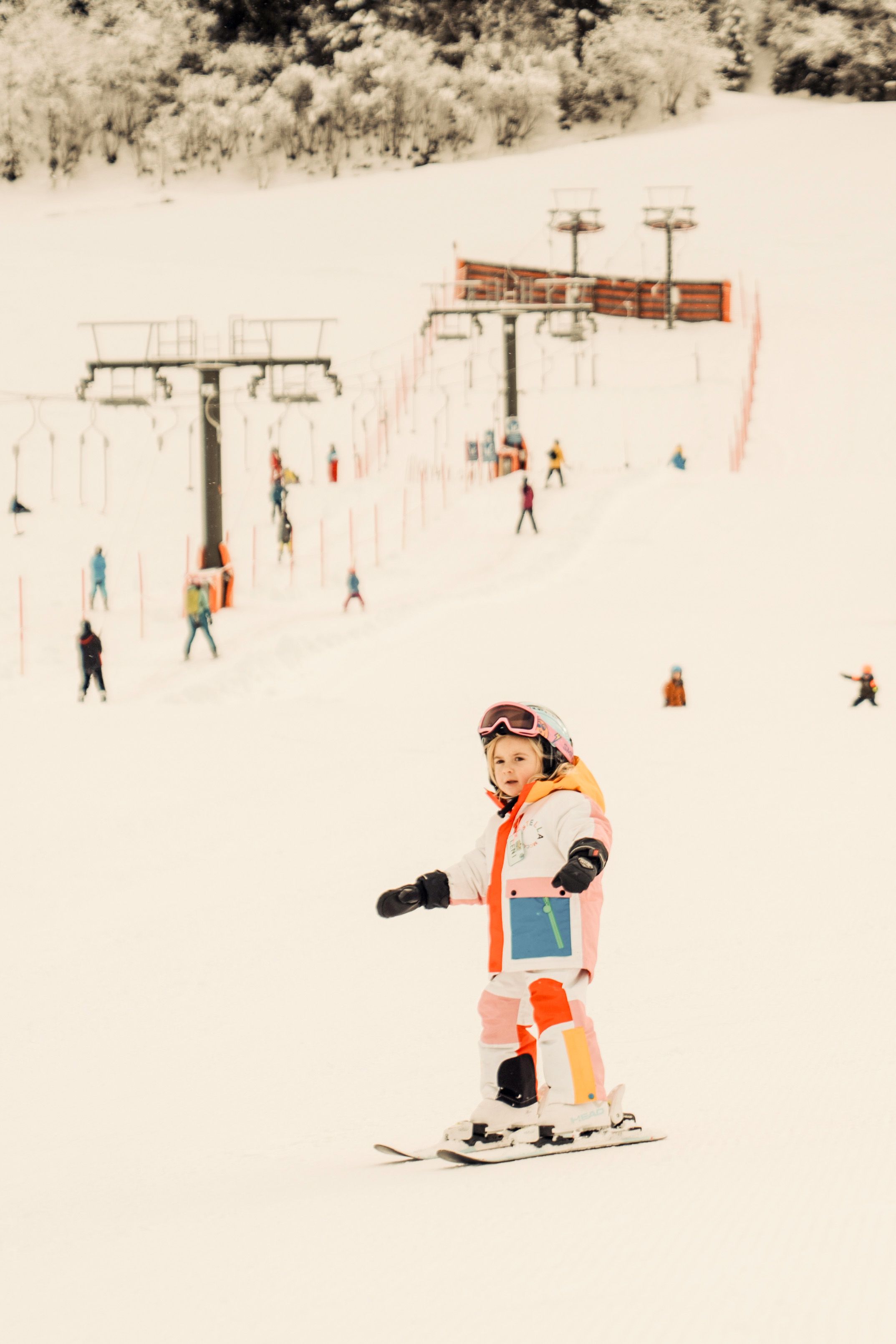 A girl is skiing in the Glemmtal, with a lift behind.