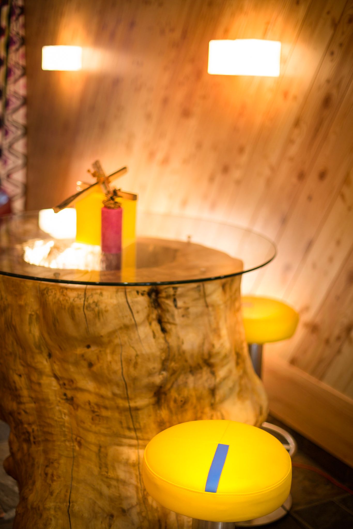 A cozy wooden table and colorful stools at the Glemmtalerhof in Hinterglemm.