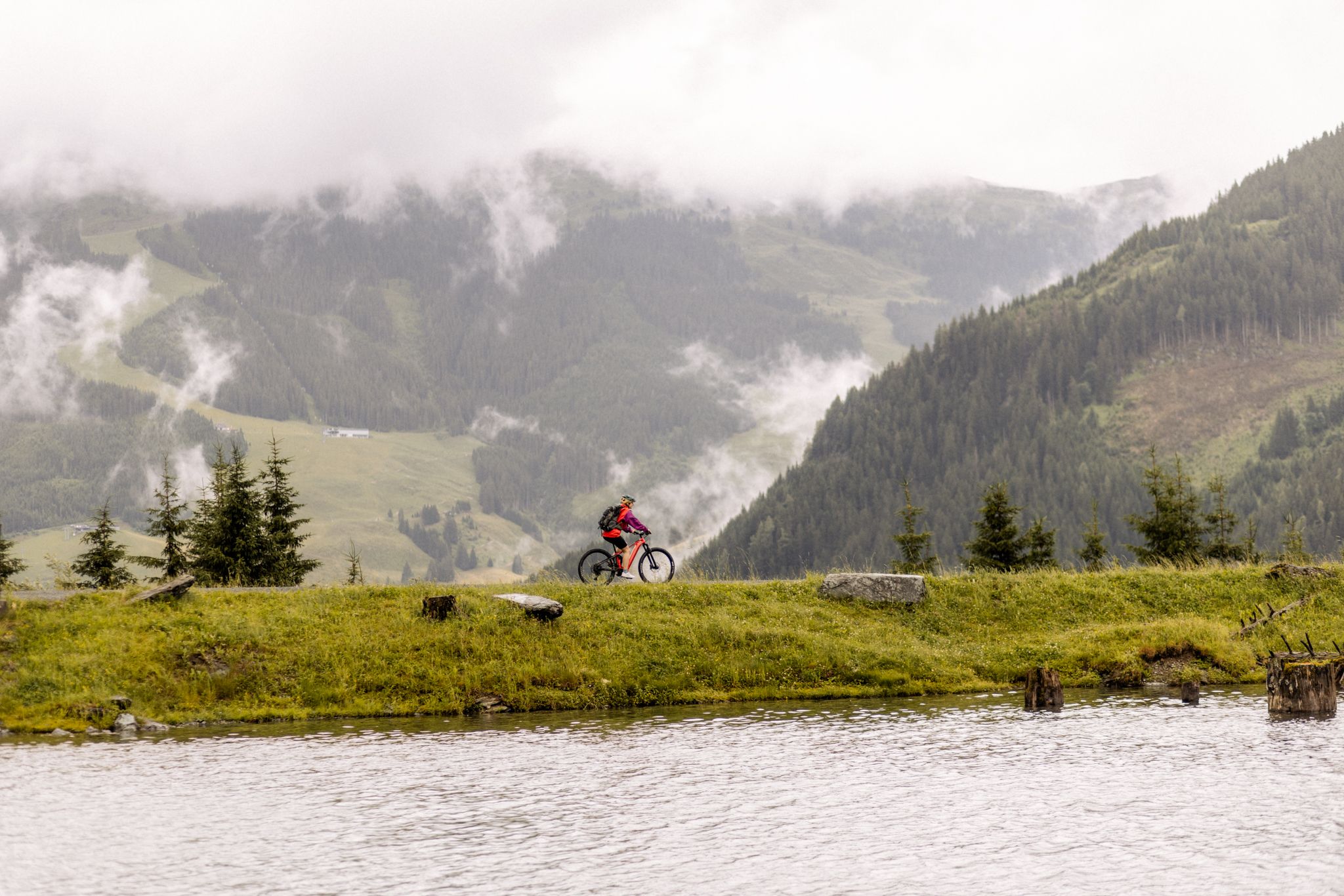 Cyclist in Glemmtal with forests and mountains behind. Beautiful natural scene in Hinterglemm