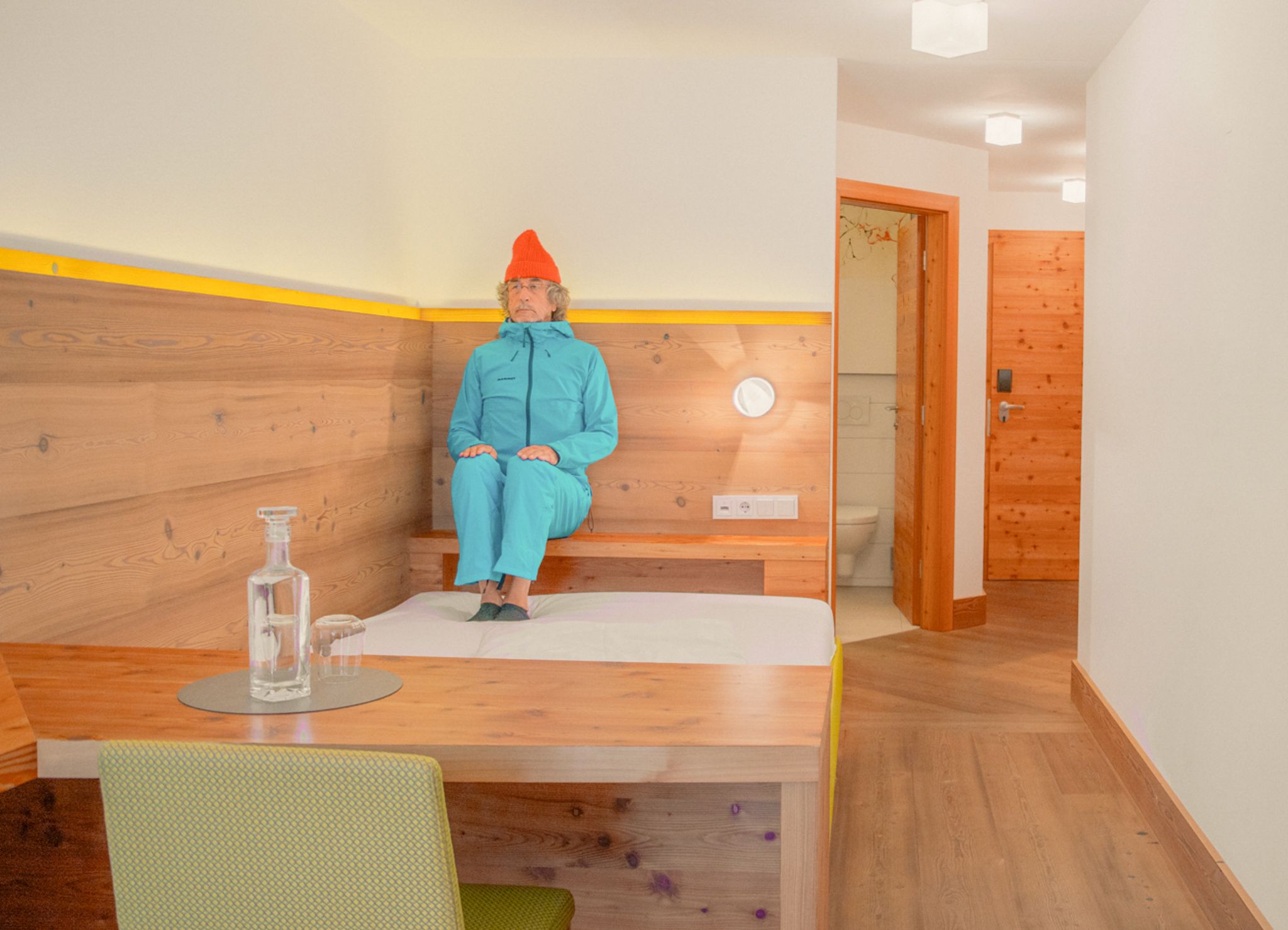 A man in a blue suit sits in a modern room at Glemmtalerhof in Hinterglemm.