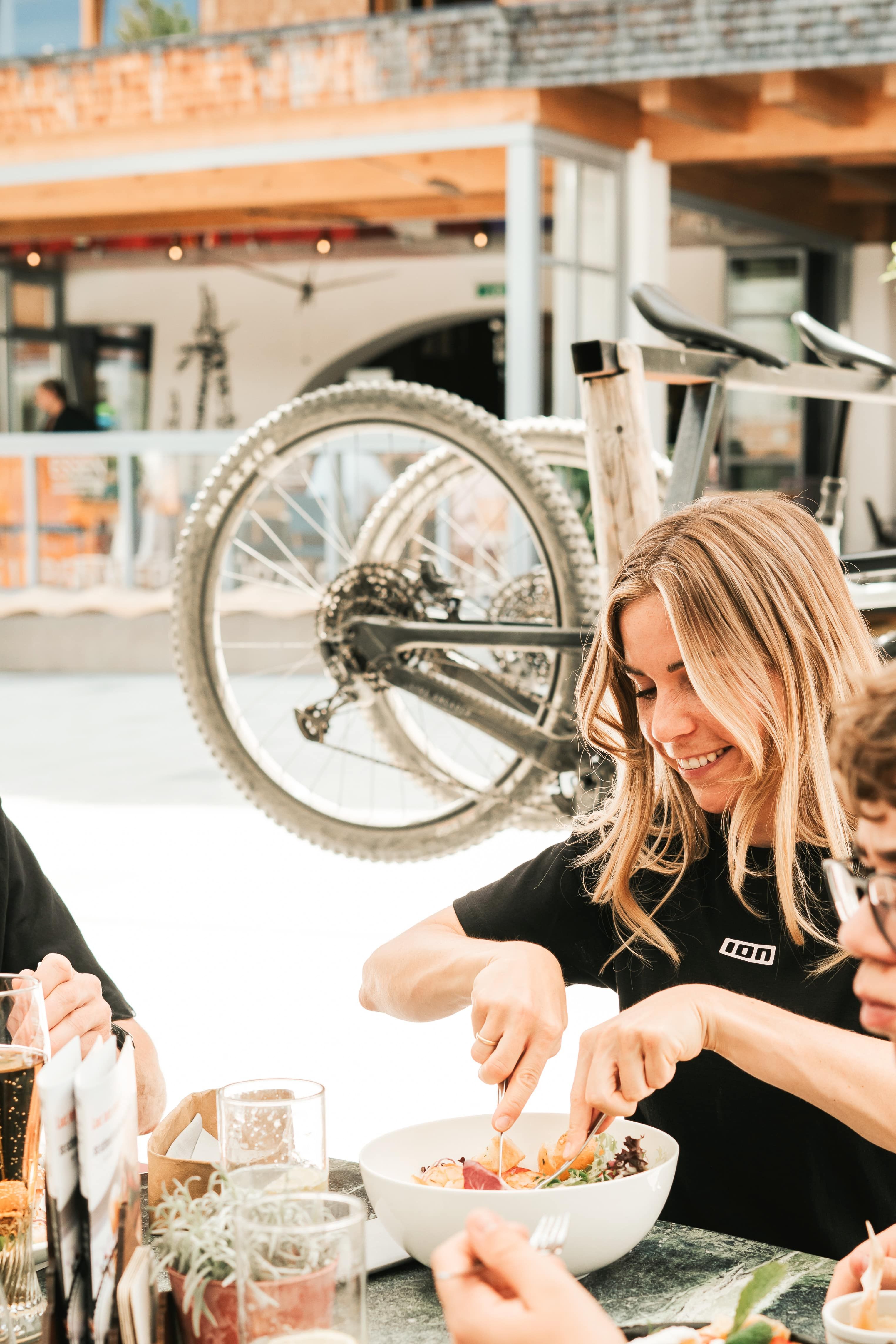 Im Glemmtalerhof in Hinterglemm genießen Gäste frische Salate und Getränke auf der Terrasse.