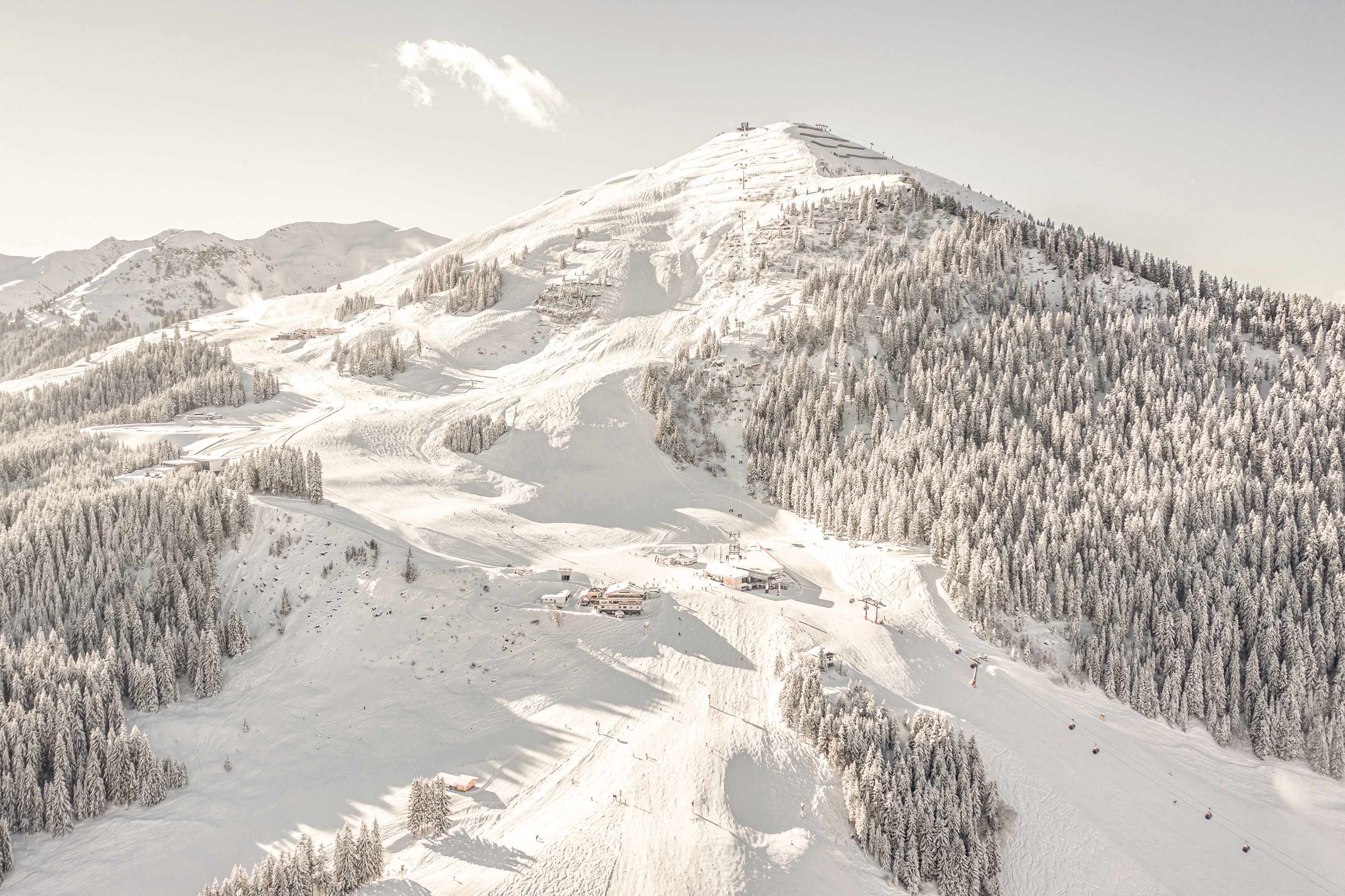 Glemmtalerhof in Hinterglemm surrounded by snowy mountains and forests.