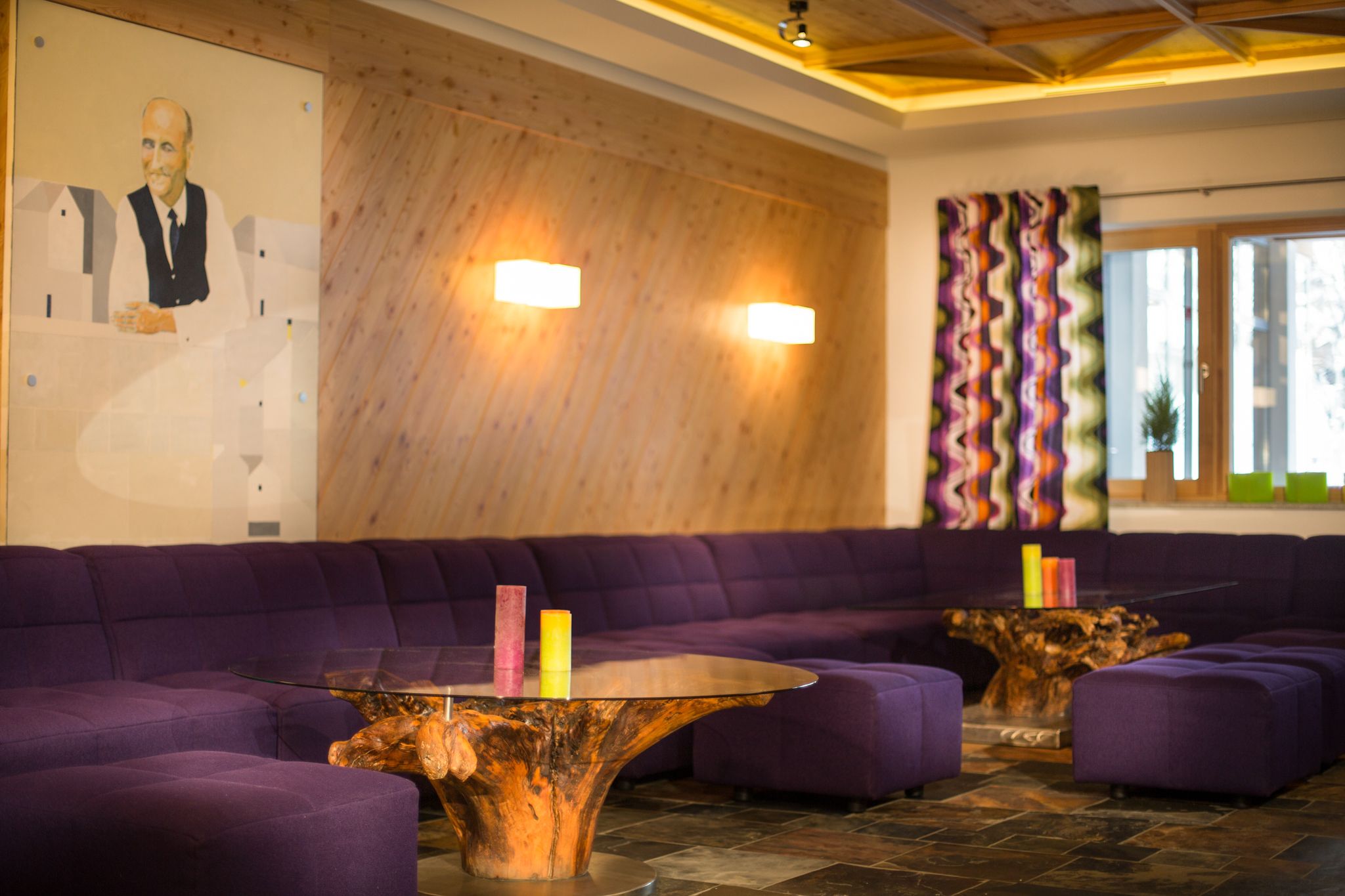 A modern living room in Glemmtalerhof, featuring purple sofas and wood decor.