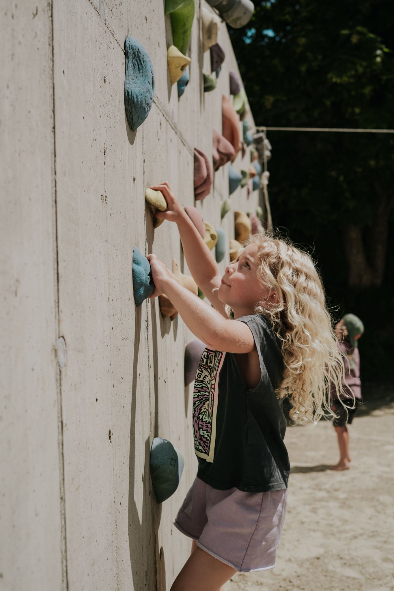 A girl climbs on a colorful climbing wall in the Glemmtal.