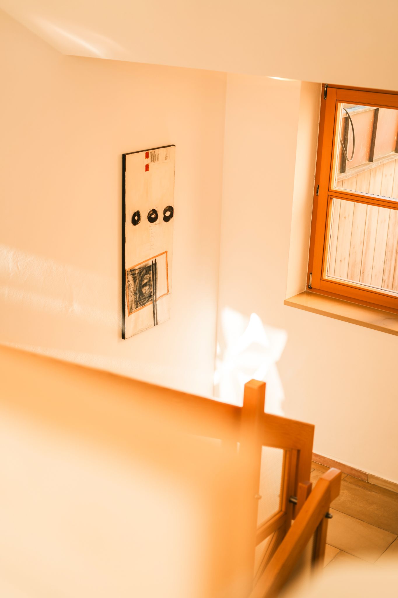 A bright hallway in Glemmtalerhof with artwork and a window.