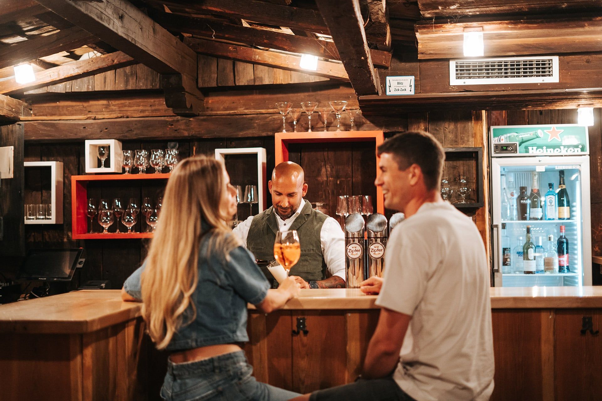In der Bar des Glemmtalerhof in Hinterglemm genießen Gäste den Abend.