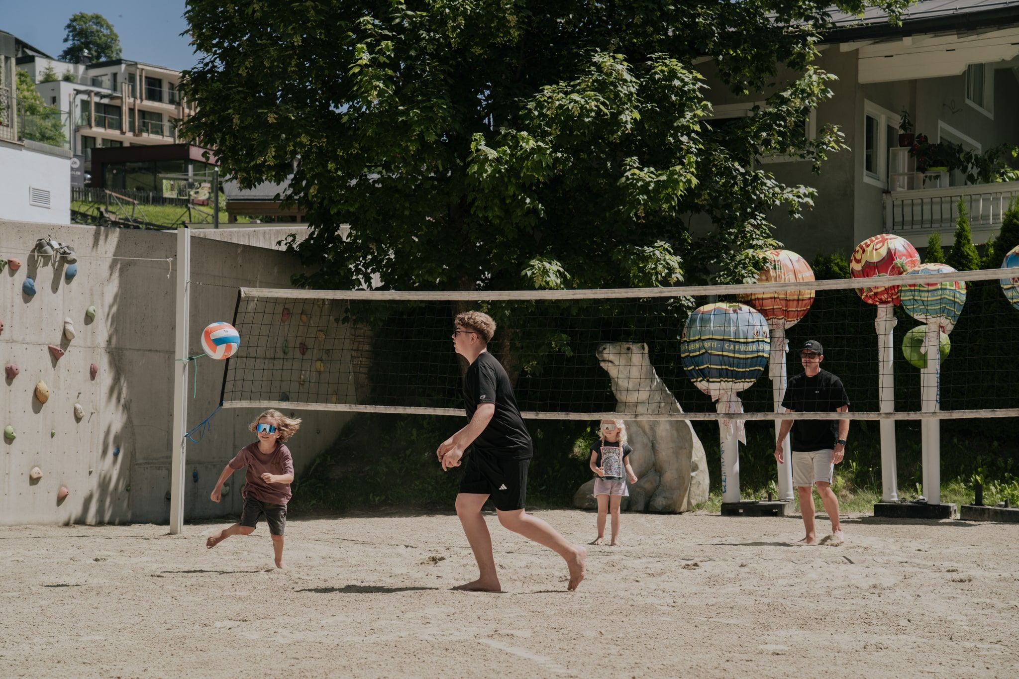 Kinder spielen Volleyball am Glemmtalerhof in Hinterglemm bei sonnigem Wetter.