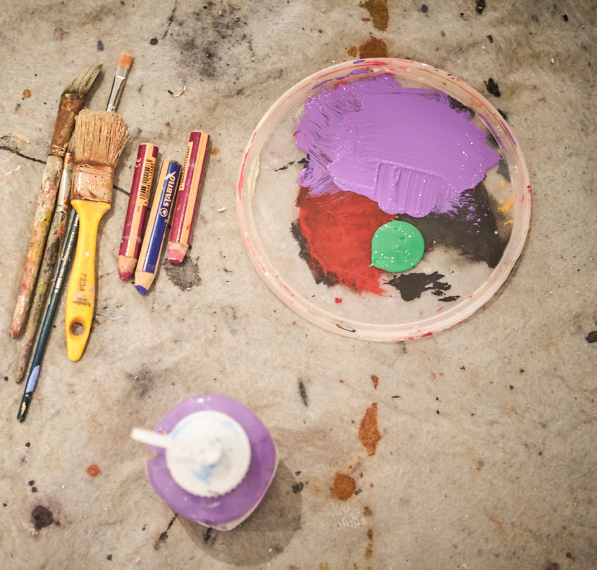 Farben und Pinsel auf einer Arbeitsfläche, kreativ und inspirierend.