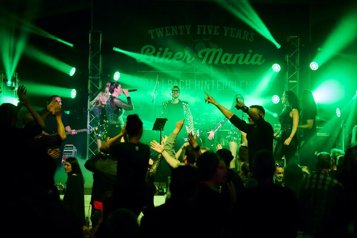 A lively music event in the Glemmtal with an enthusiastic audience and bright lights.