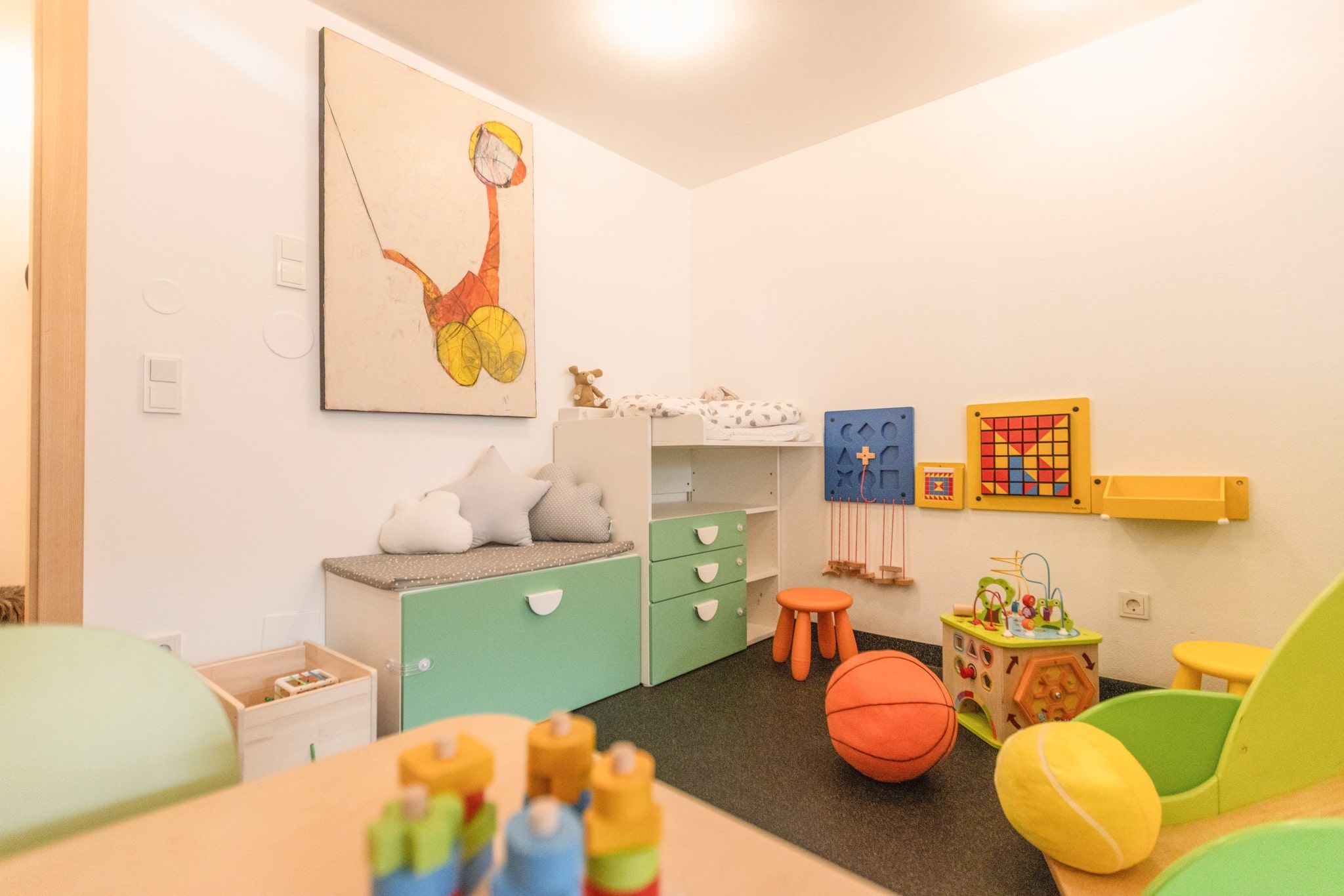 Ein farbenfrohes Kinderzimmer mit Spielzeug und Kunstwerk. Ideal für die Gäste des Glemmtalerhofs in Hinterglemm.