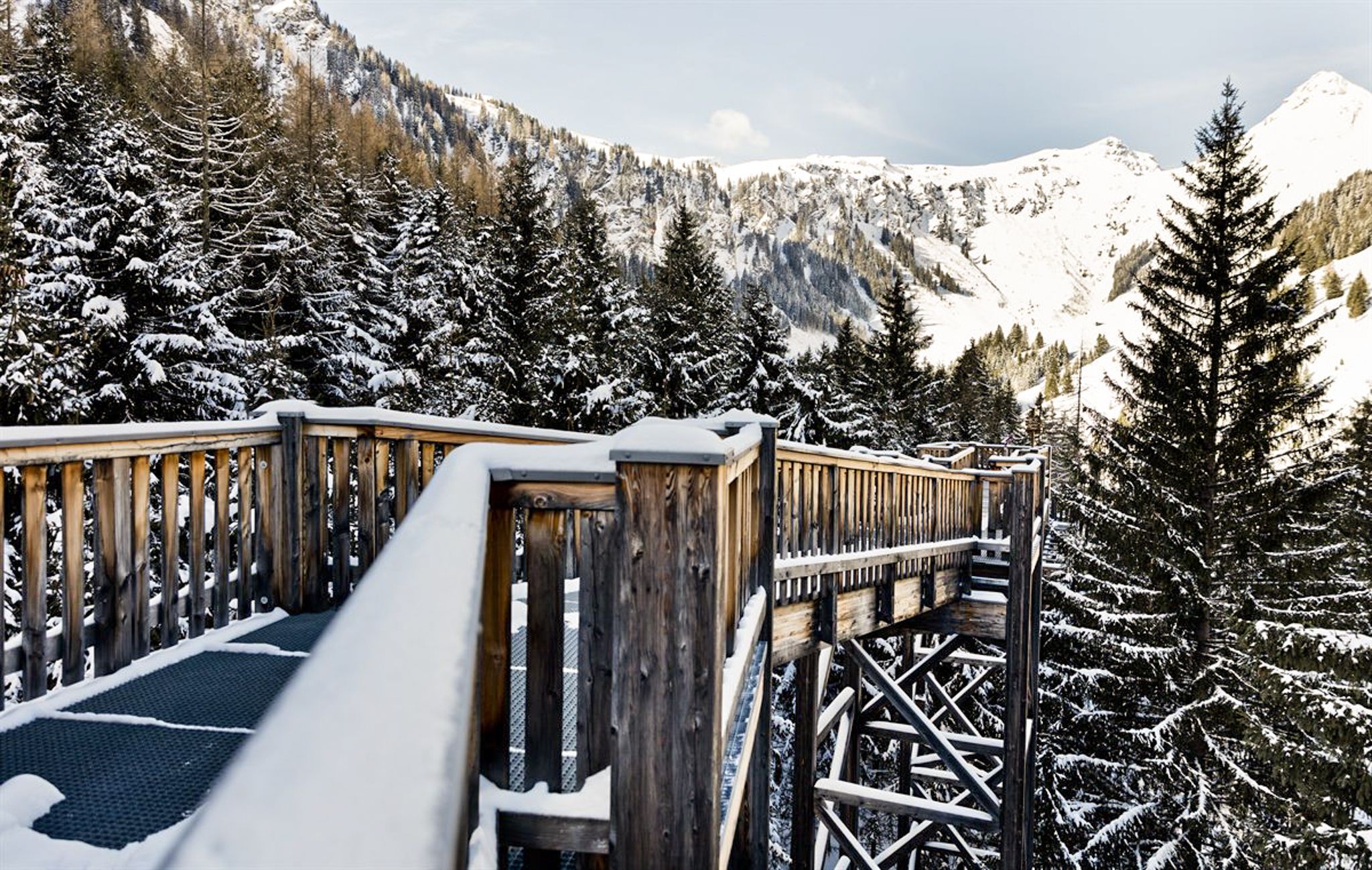 Beautiful wooden walkway in the snowy Glemmtal with stunning mountain views