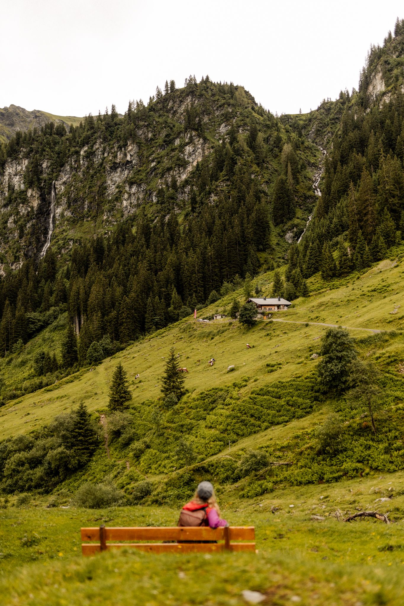 A person sits on a bench admiring the mountains in Glemmtal.