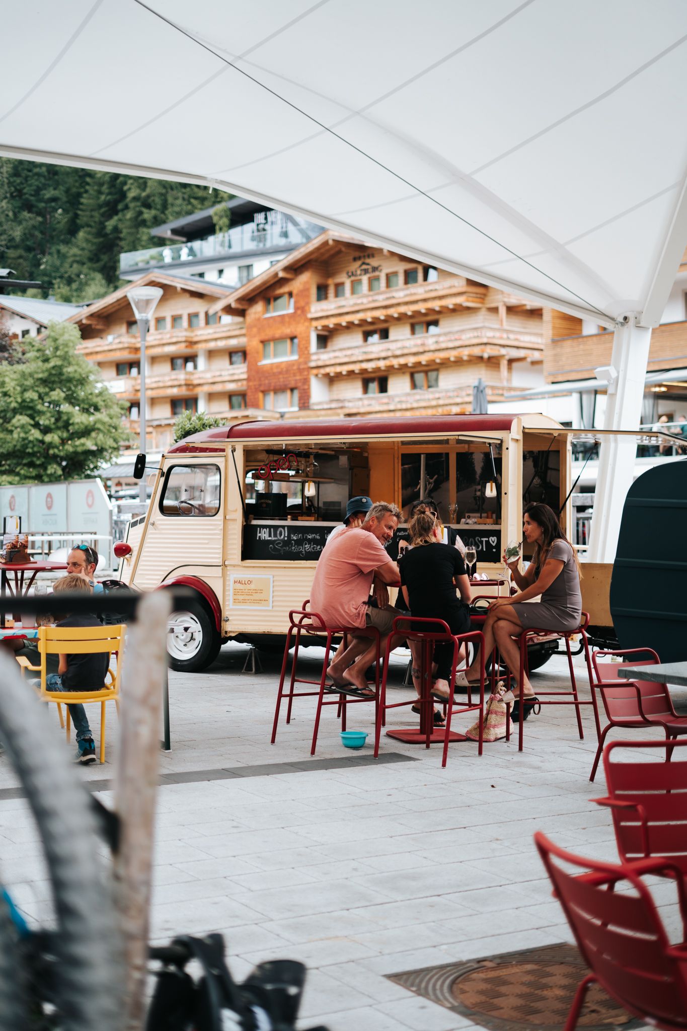 Guests enjoy food and drinks in front of the Glemmtalerhof in Hinterglemm.