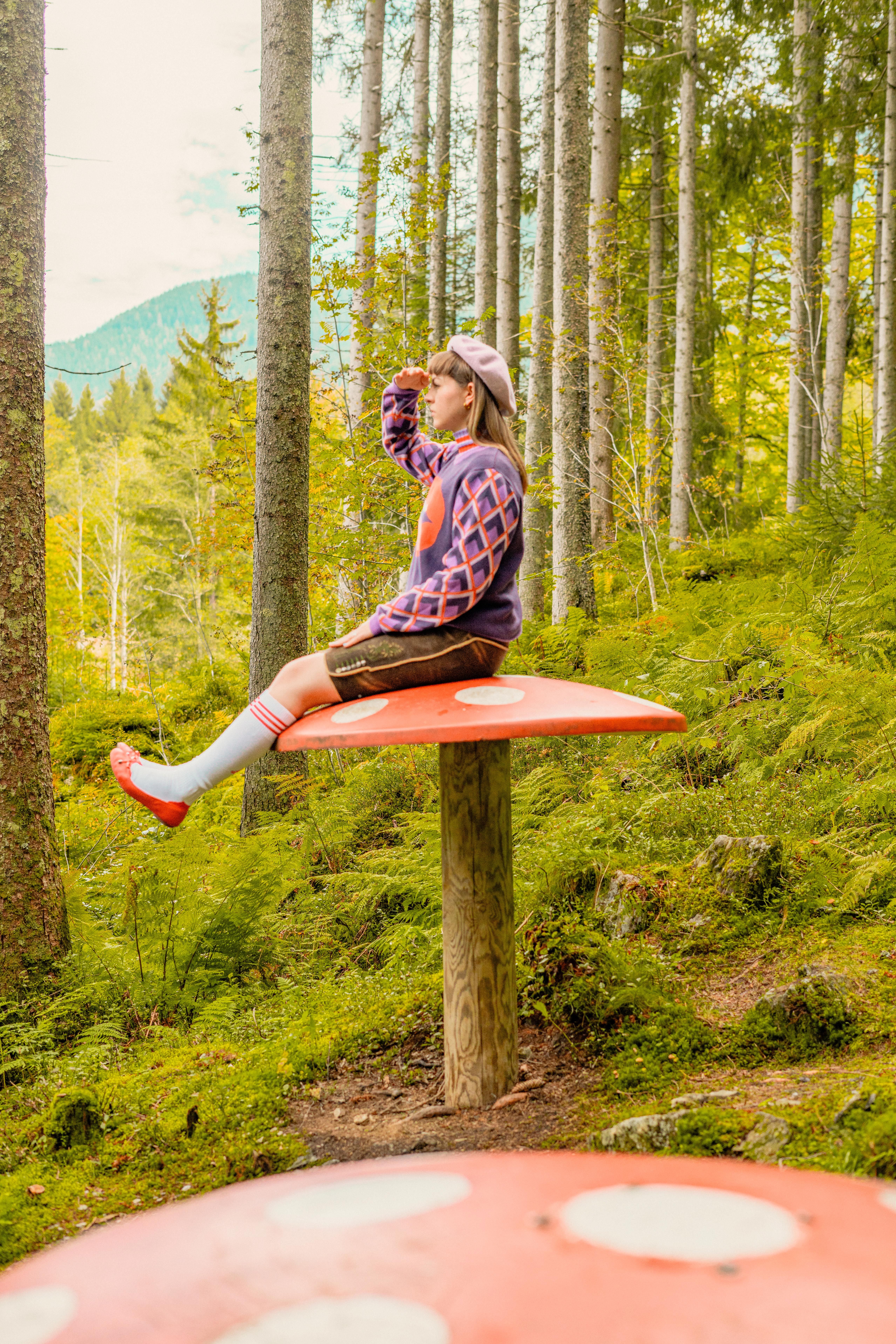 A girl sits on a large mushroom in Glemmtal, looking into the distance.