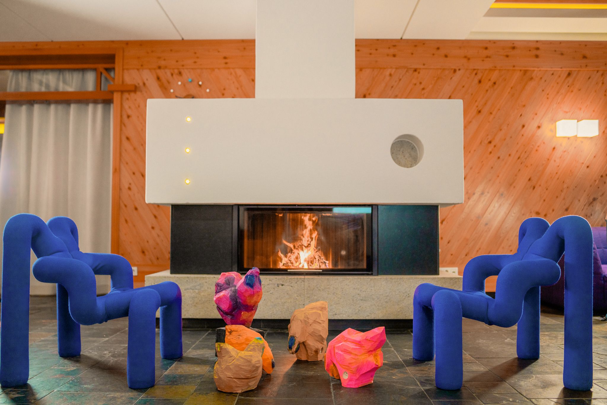 Cozy room with colorful chairs and a fireplace at Glemmtalerhof in Hinterglemm.