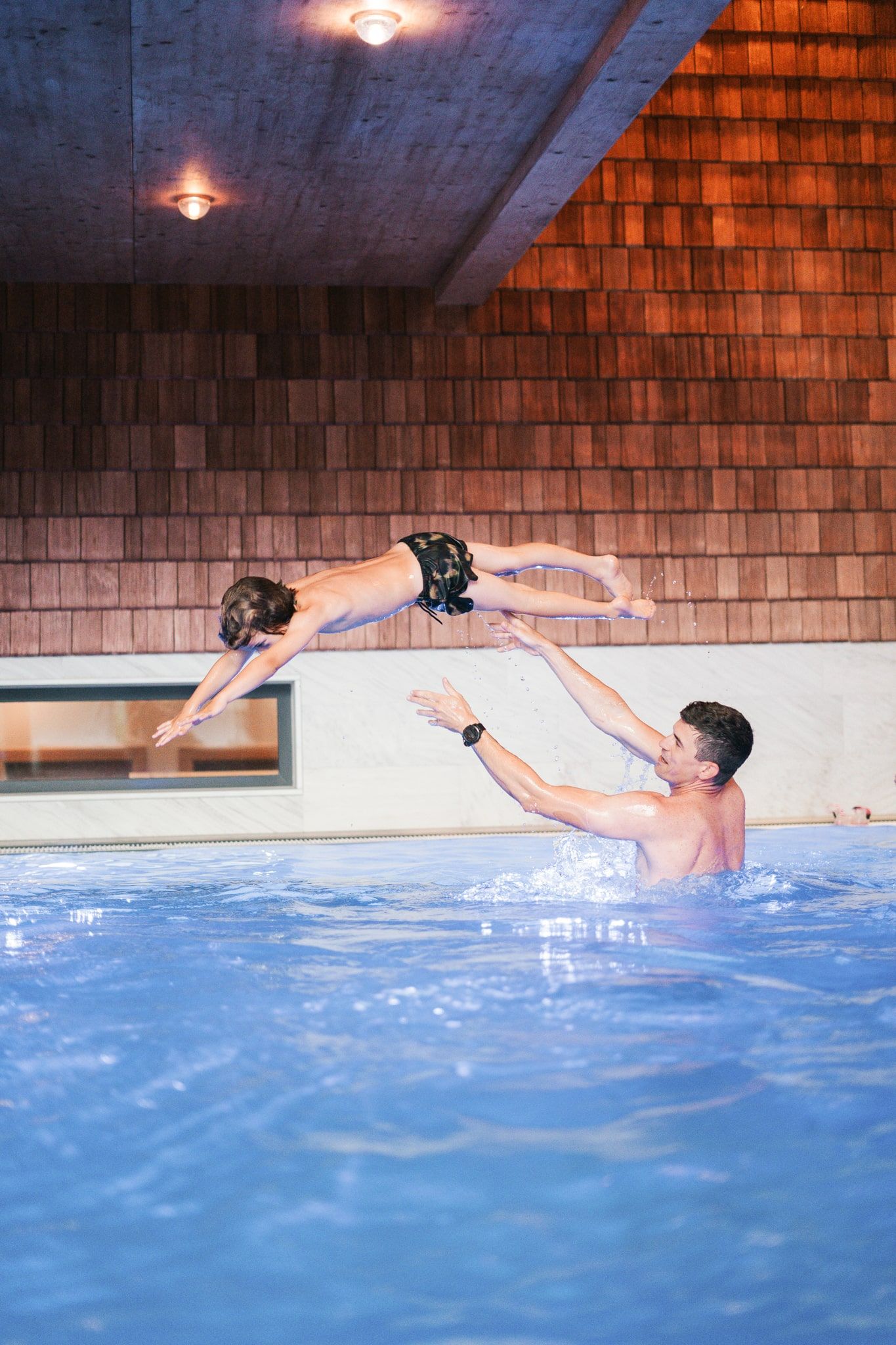 Ein Vater wirft sein Kind ins Wasser im Glemmtalerhof in Hinterglemm.