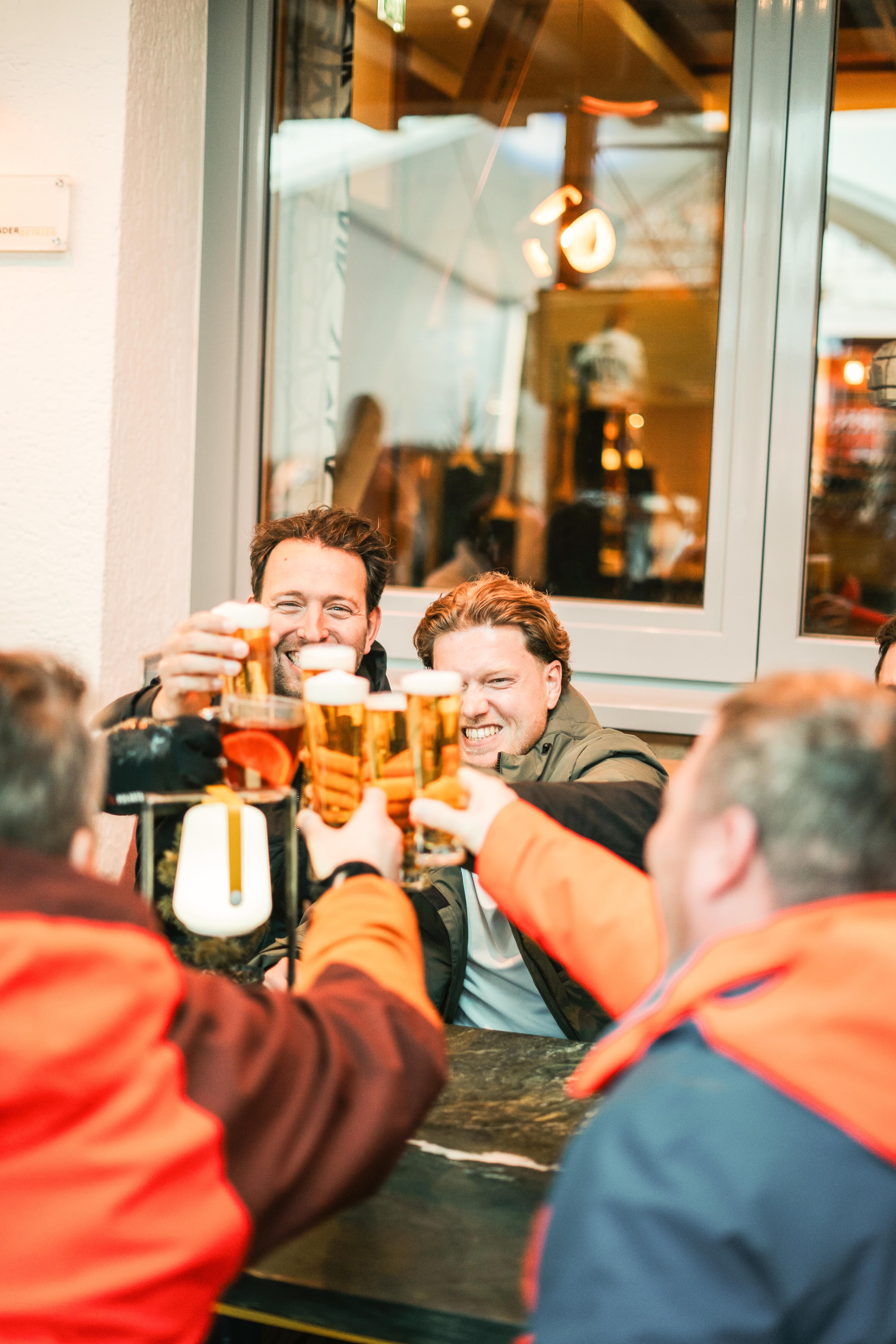 Friends cheerfully toast at Glemmtalerhof in Hinterglemm.