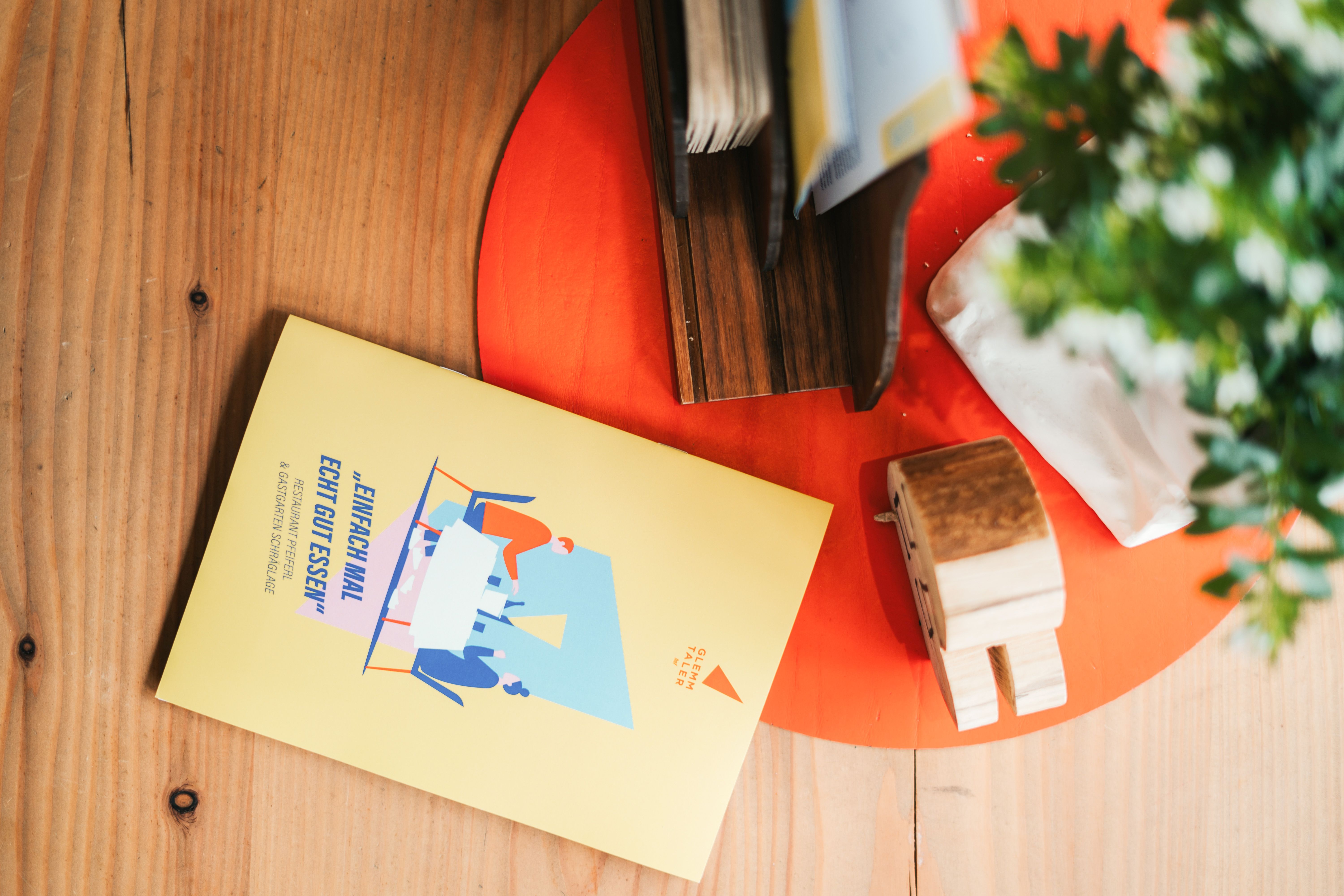 A colorful menu from Glemmtalerhof in Hinterglemm rests on a wooden table.