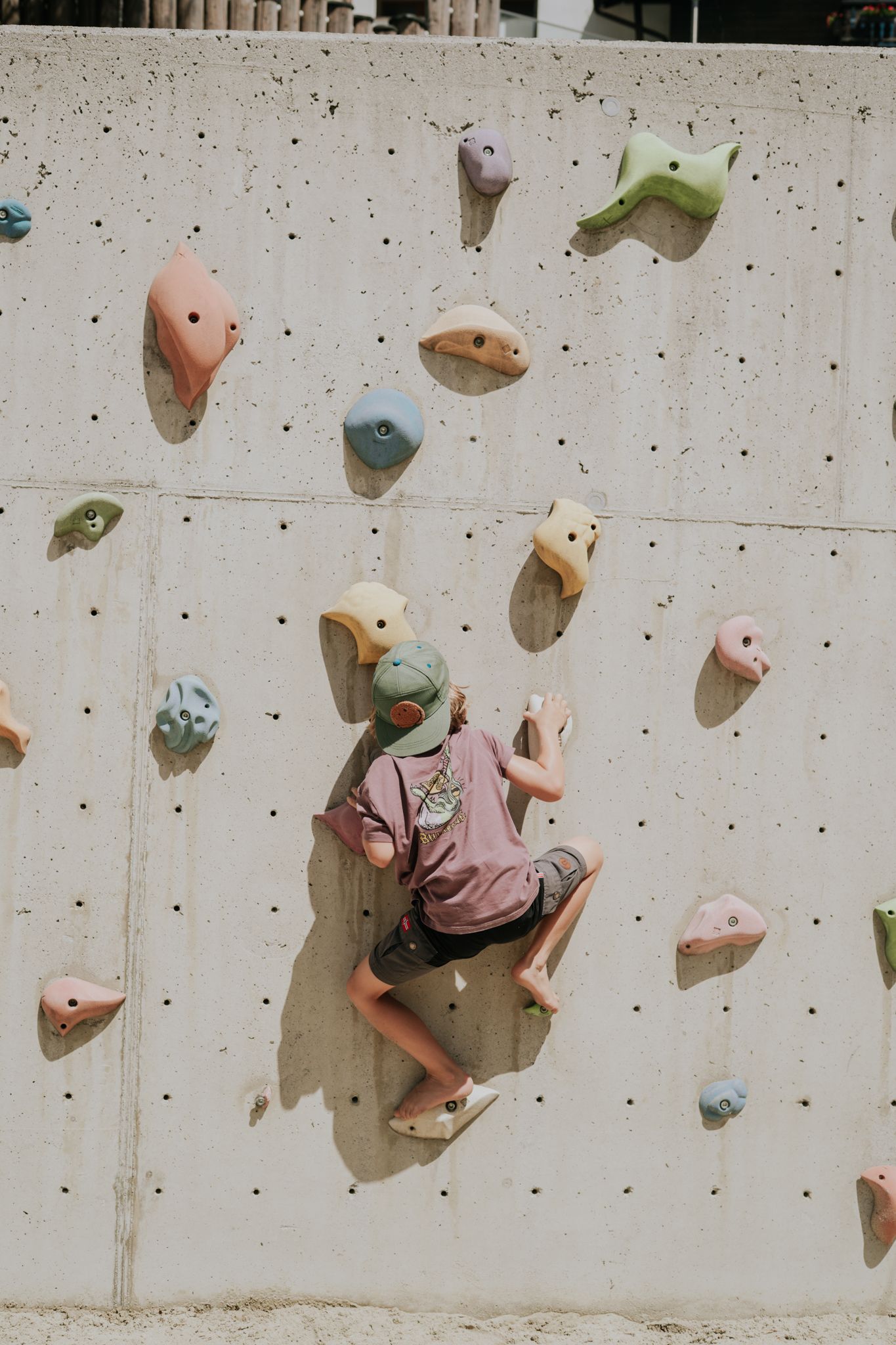 A child is climbing on a climbing wall in the Glemmtal.