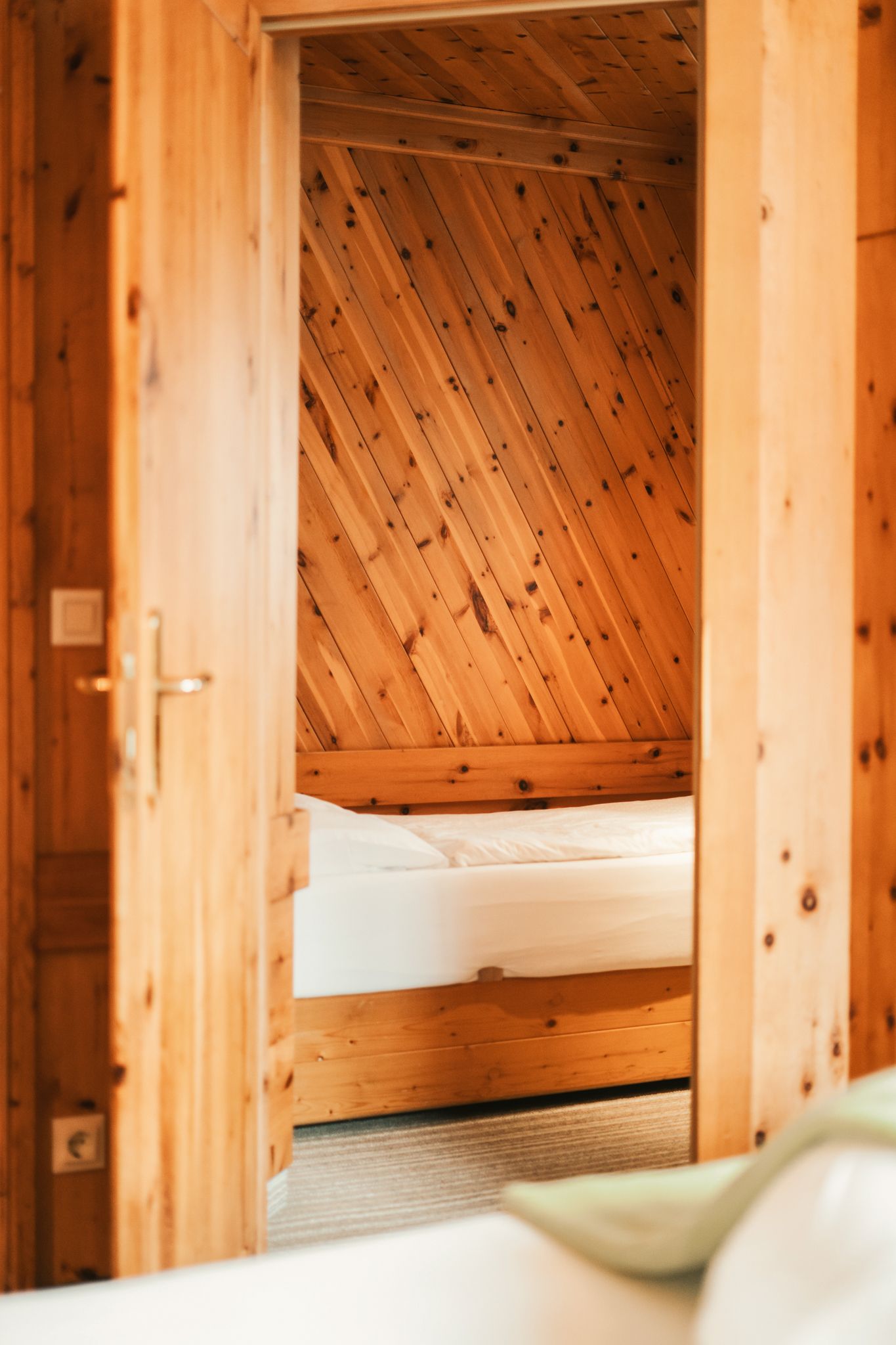 Bright room with wood paneling and a bed at Glemmtalerhof in Hinterglemm.
